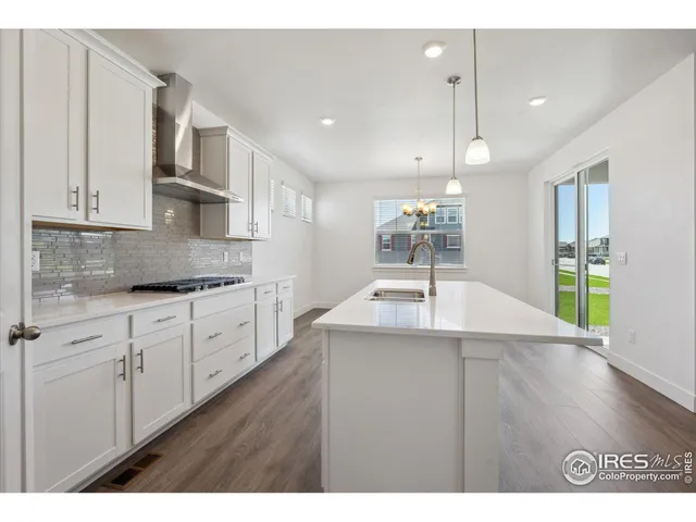 a kitchen with kitchen island a sink granite counter tops and a view of living room