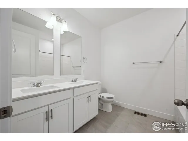 a bathroom with a toilet a sink a mirror and vanity