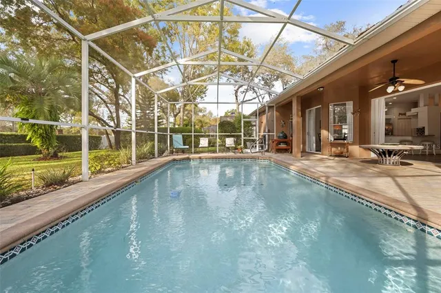 a view of a swimming pool with a patio and a yard