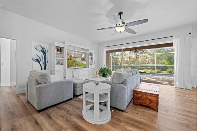 a living room with furniture a chandelier and a large window