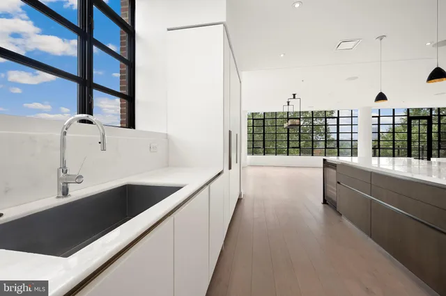 a view of a kitchen with kitchen island a large window a sink and a counter top space