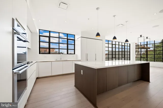 a kitchen with stainless steel appliances kitchen island granite countertop a stove and a sink