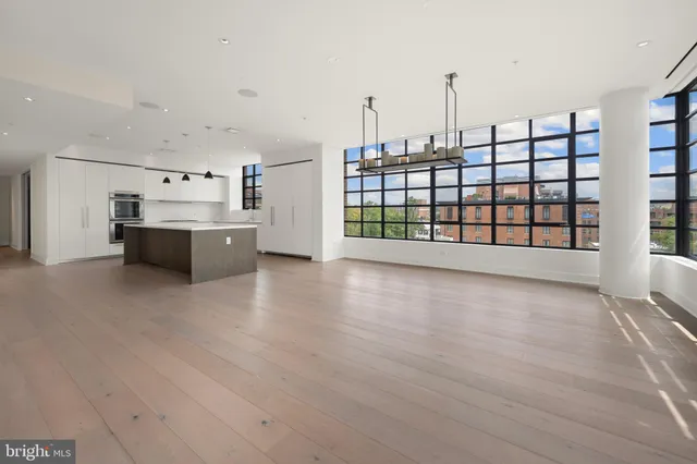 a view of a kitchen with stainless steel appliances wooden floor and large windows