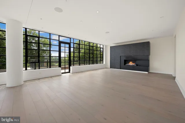 a view of an empty room with a fireplace and a window