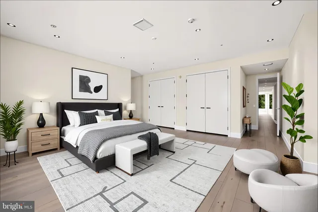 a spacious bedroom with a bed a couch and a large window