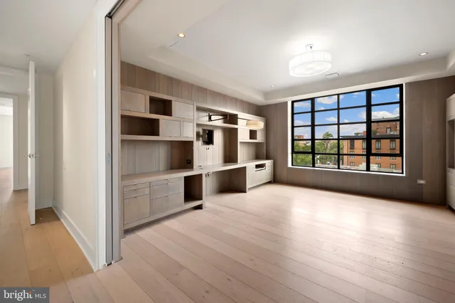 a view of an empty room with window and cabinet