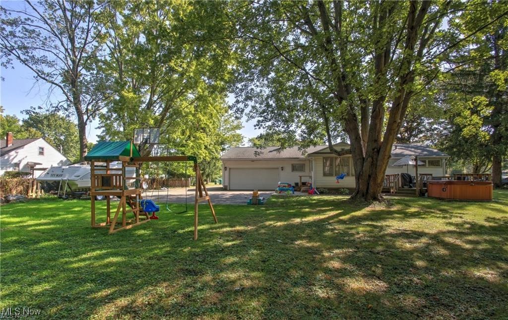 7368 Hopkins Road Mentor, OH 44060 - Photo 31 of 37 View of yard with a playground, an attached garage, and a hot tub