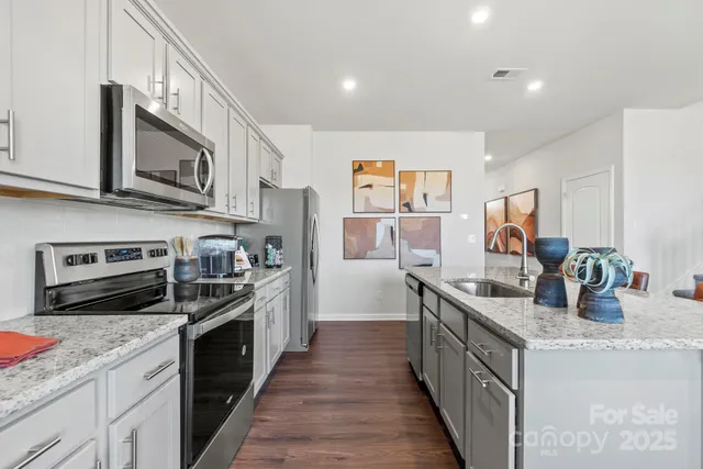 a kitchen with stainless steel appliances granite countertop a stove top oven a sink and dishwasher