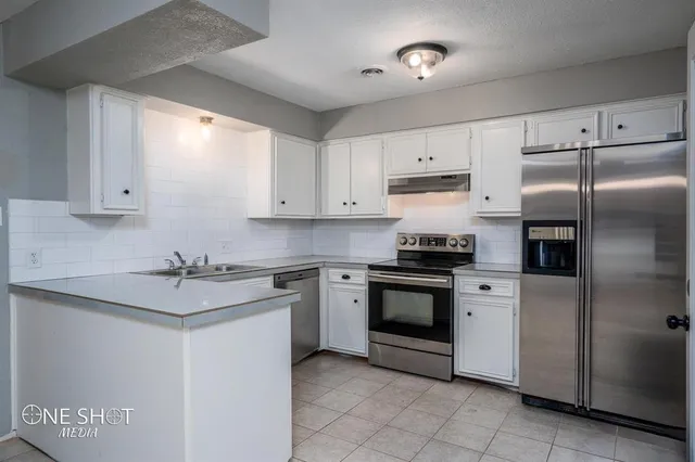 a kitchen with stainless steel appliances granite countertop a sink and a refrigerator