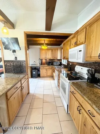 a large kitchen with a stove a sink dishwasher and a refrigerator