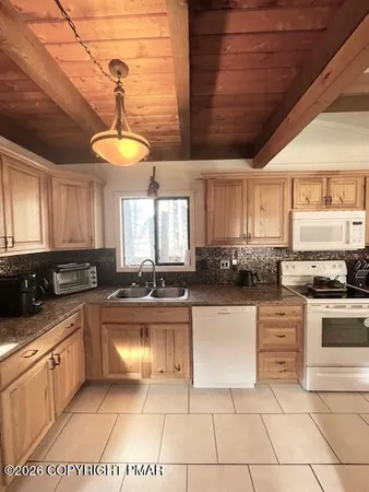 a kitchen with a stove a sink a microwave and cabinets