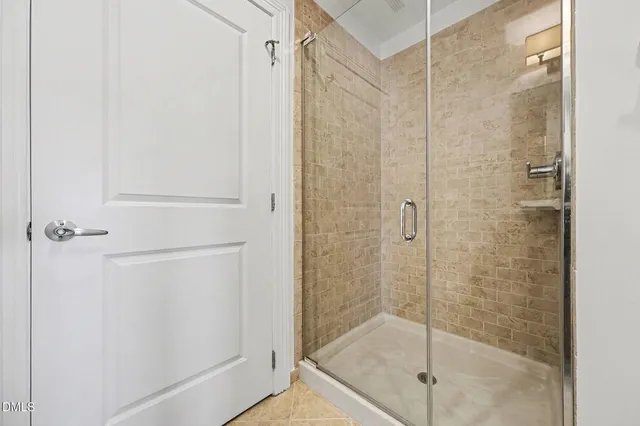 an empty room with a chandelier fan and windows