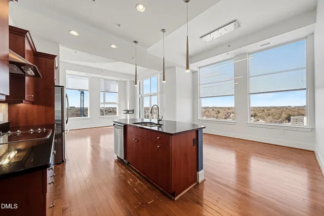 a kitchen with stainless steel appliances granite countertop a stove and a wooden floors