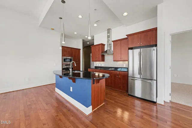 a kitchen with stainless steel appliances granite countertop a refrigerator and a stove top oven
