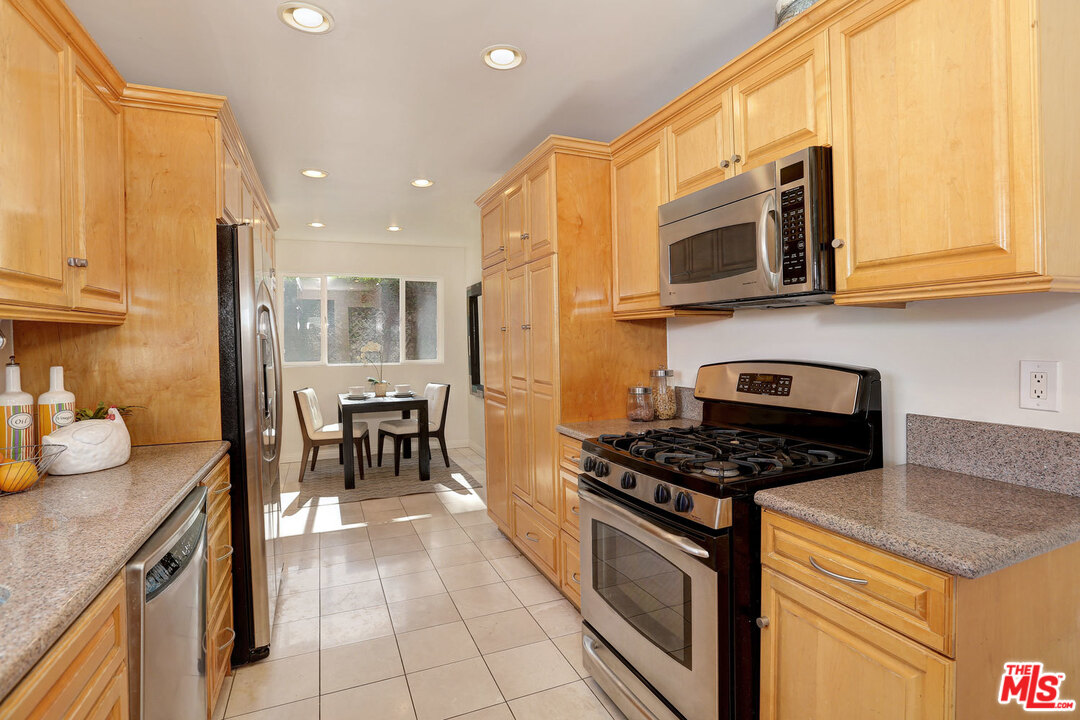 3838 Crestview Road Culver City, CA 90232 - Photo 14 of 29 a kitchen with stainless steel appliances granite countertop a stove a sink and a microwave