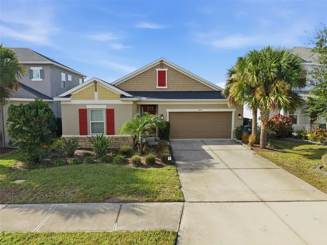 a front view of a house with a yard and potted plants