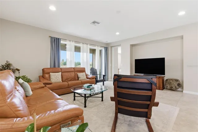 a view of an empty room and chandelier fan