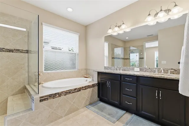 an empty room with a chandelier fan and windows