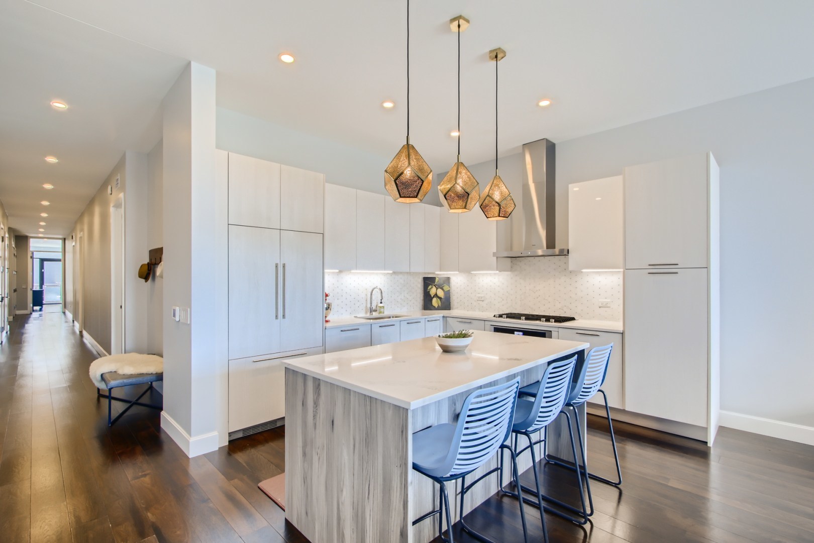 31 North Aberdeen Street, Unit PHS Chicago, IL 60607 - Photo 8 of 28 a kitchen with a table a stove a sink dishwasher and white cabinets with wooden floor