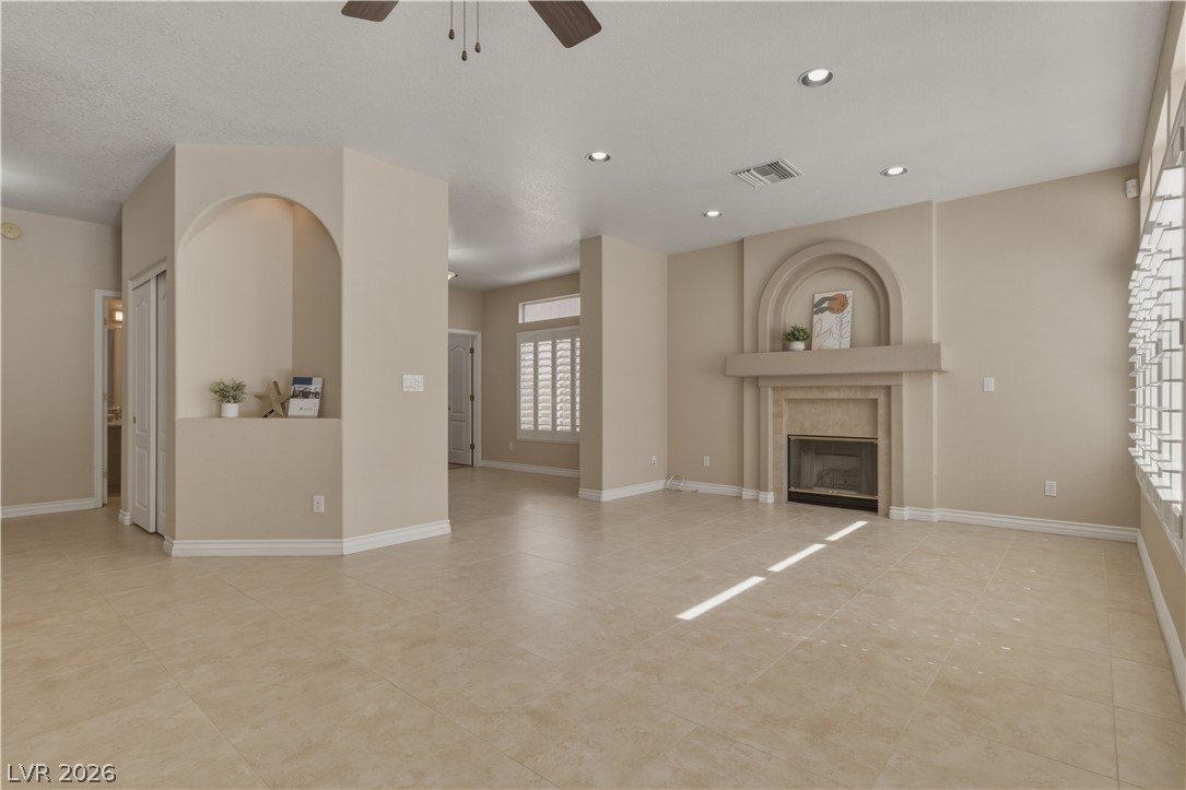 29 Olive Tree Henderson, NV 89074 - Photo 18 of 60 This expansive living area features a charming fireplace and neutral tile flooring.