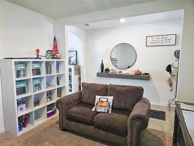 a living room with furniture and a book shelf