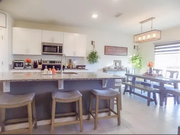 a kitchen with a dining table chairs and microwave