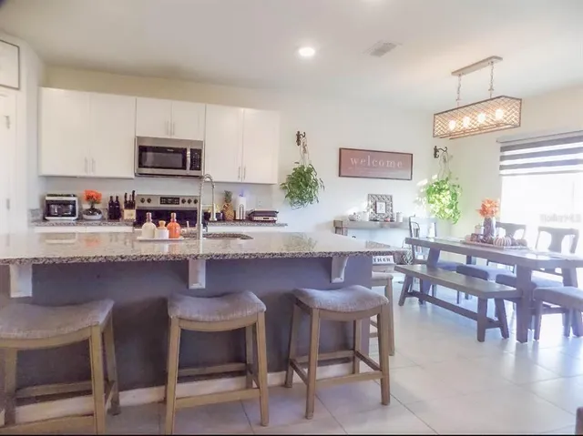 a kitchen with a dining table chairs and microwave