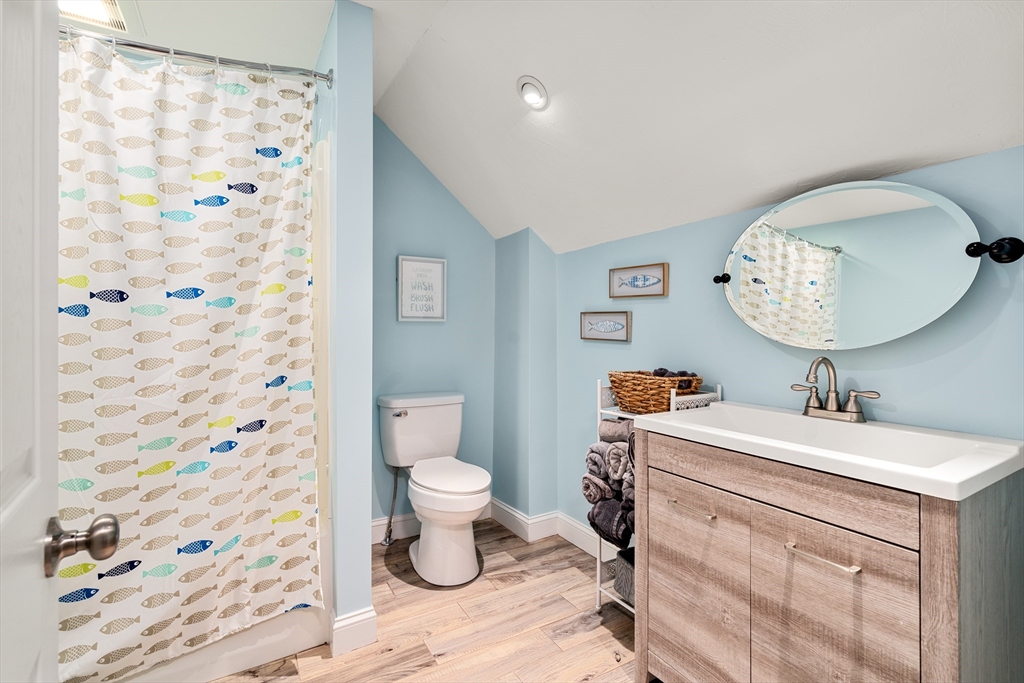10 Cedar Street Hudson, MA 01749 - Photo 20 of 38 a bathroom with a sink toilet a mirror and shower curtain