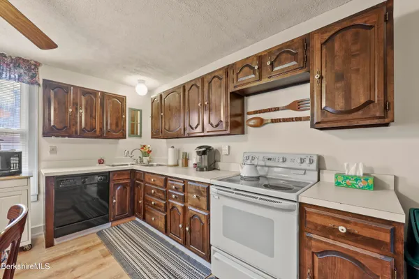 a kitchen with stainless steel appliances granite countertop a sink stove and cabinets