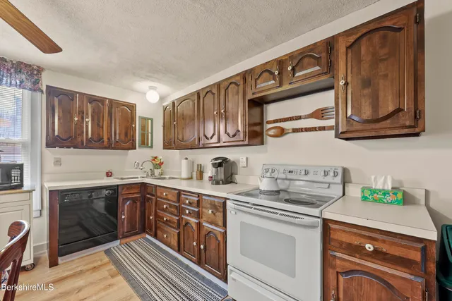 a kitchen with stainless steel appliances granite countertop a sink stove and cabinets
