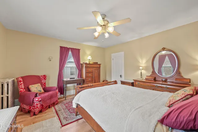 a bedroom with a bed a chandelier and a mirror