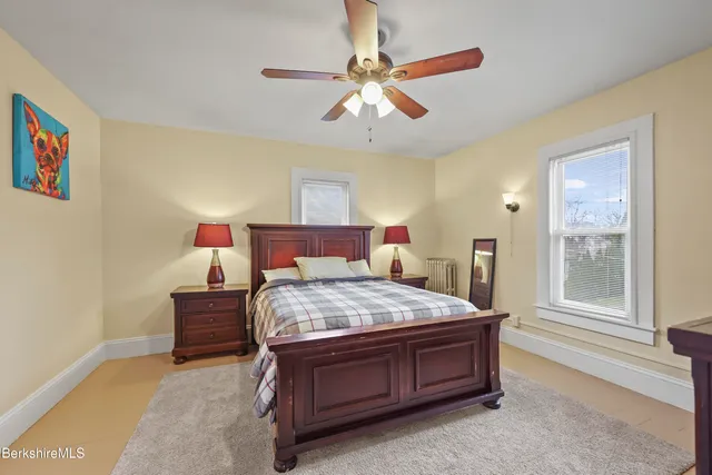 a bed sitting in a bedroom next to a window