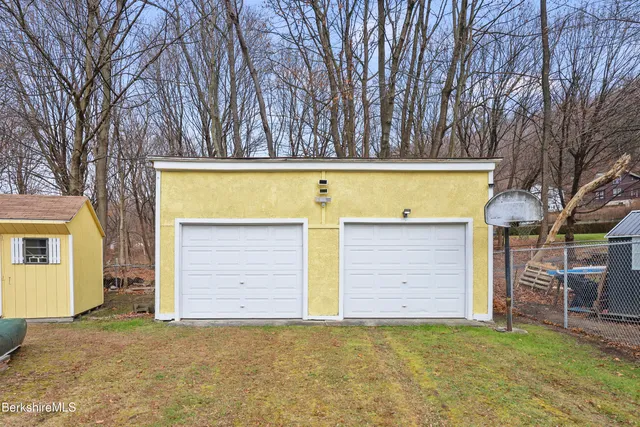 a view of a house with backyard and trees