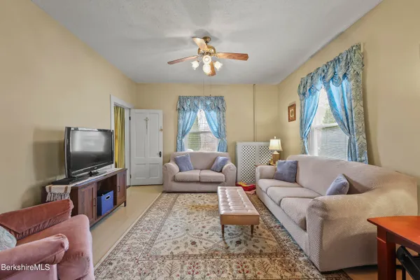 a living room with furniture a flat screen tv and a large window