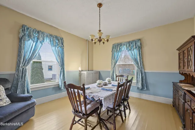 a dining room with furniture a chandelier and window