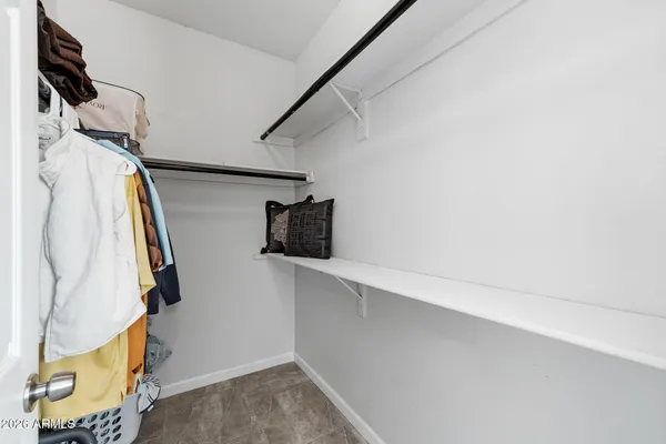 a view of walk in closet with clothes and shoes