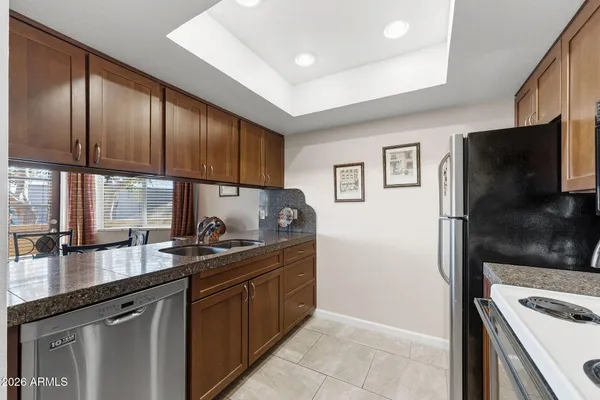 a kitchen with stainless steel appliances granite countertop a sink stove and refrigerator