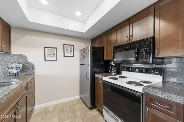 a kitchen with stainless steel appliances granite countertop a stove a sink and a microwave