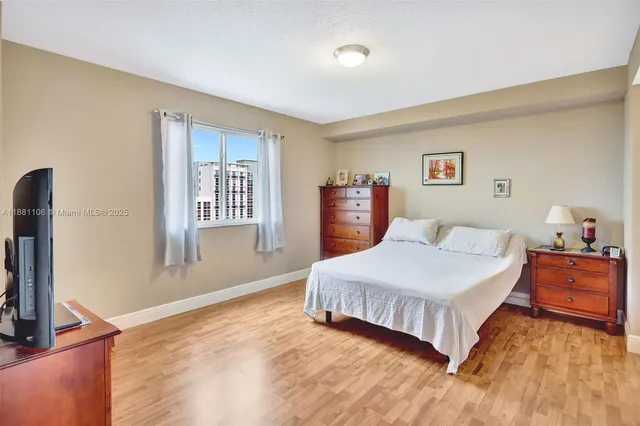 a spacious bedroom with a bed and a flat screen tv