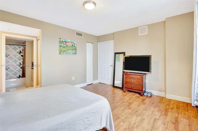 a bedroom with a bed and a flat screen tv