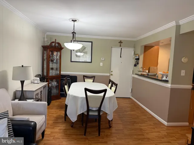 a dining room with furniture a chandelier and wooden floor