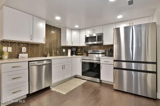 a kitchen with granite countertop stainless steel appliances and refrigerator