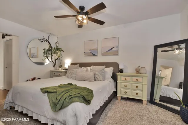 a bedroom with a large bed and a chandelier