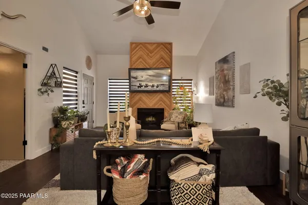 a living room with furniture a fireplace and potted plants