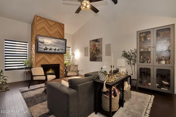 a living room with furniture a fireplace and a flat screen tv