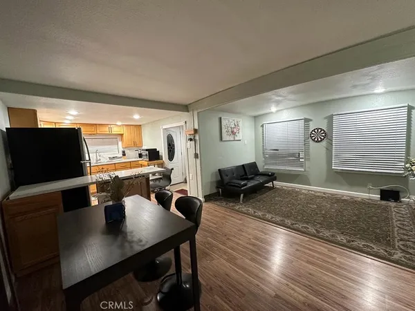 a living room with furniture a flat screen tv and kitchen view