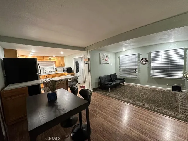 a living room with furniture a flat screen tv and kitchen view