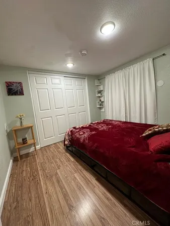 a spacious bedroom with a bed and wooden floor