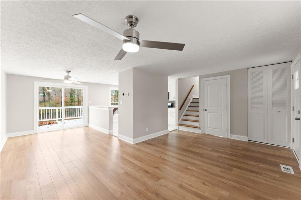 3467 Centerville Lane Southwest Snellville, GA 30039 - Photo 7 of 44 a view of an empty room with wooden floor and a ceiling fan