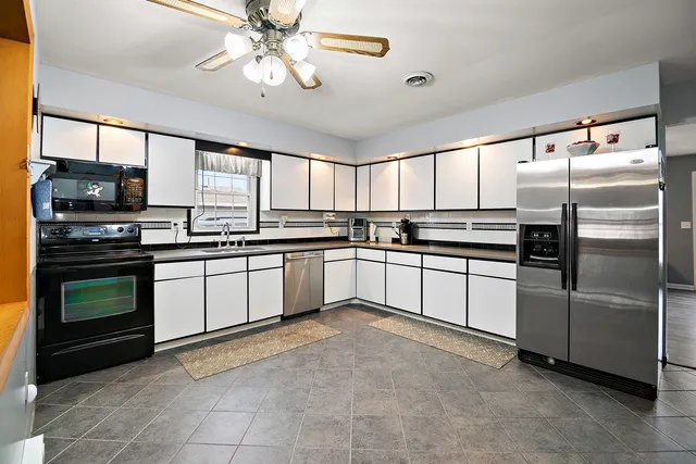 a kitchen with granite countertop stainless steel appliances and white cabinets